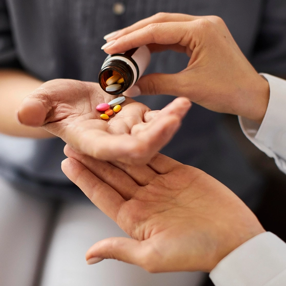 covid recovery center female doctor giving elder patient pills from bottle hand 1